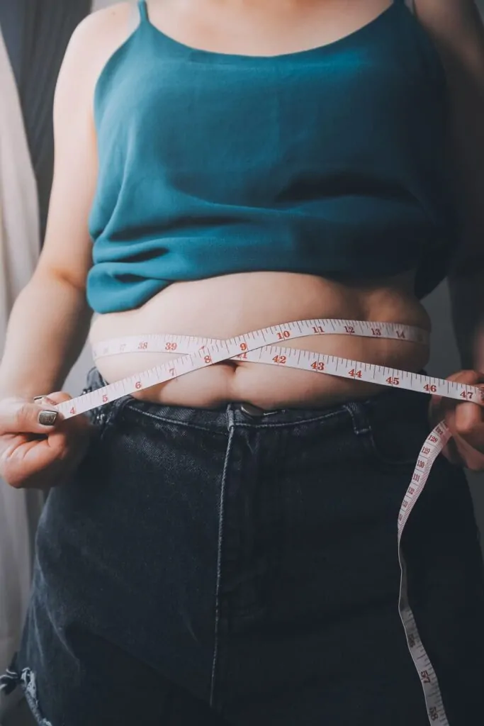 woman measuring her tummy before lipo