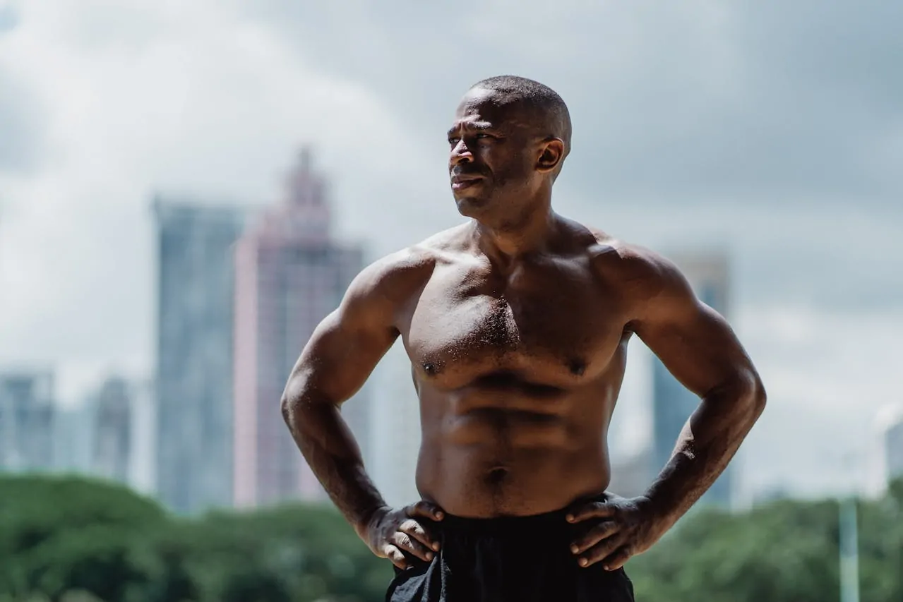 A shirtless man flexing his abs after liposuction