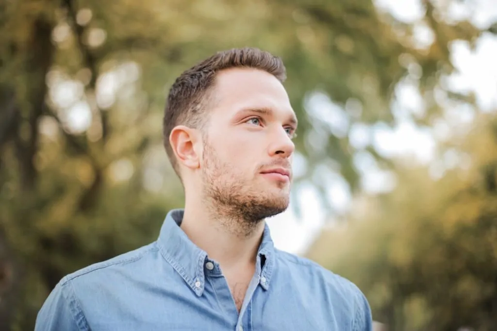 A man flexing his pretty face after a FaceTite procedure