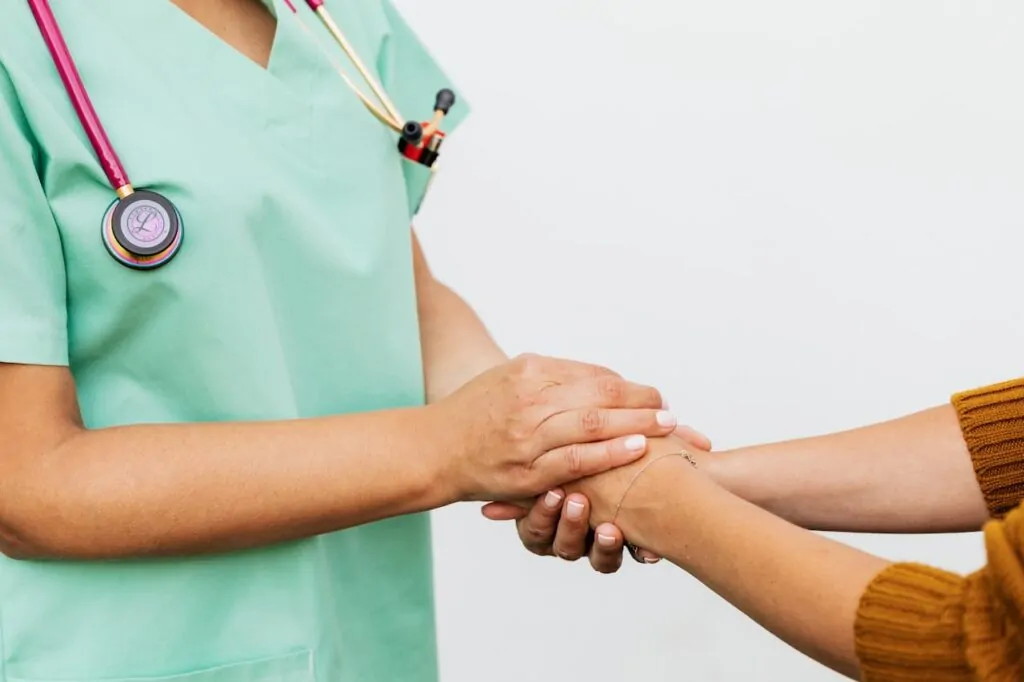 surgeon holding the hands of a patient