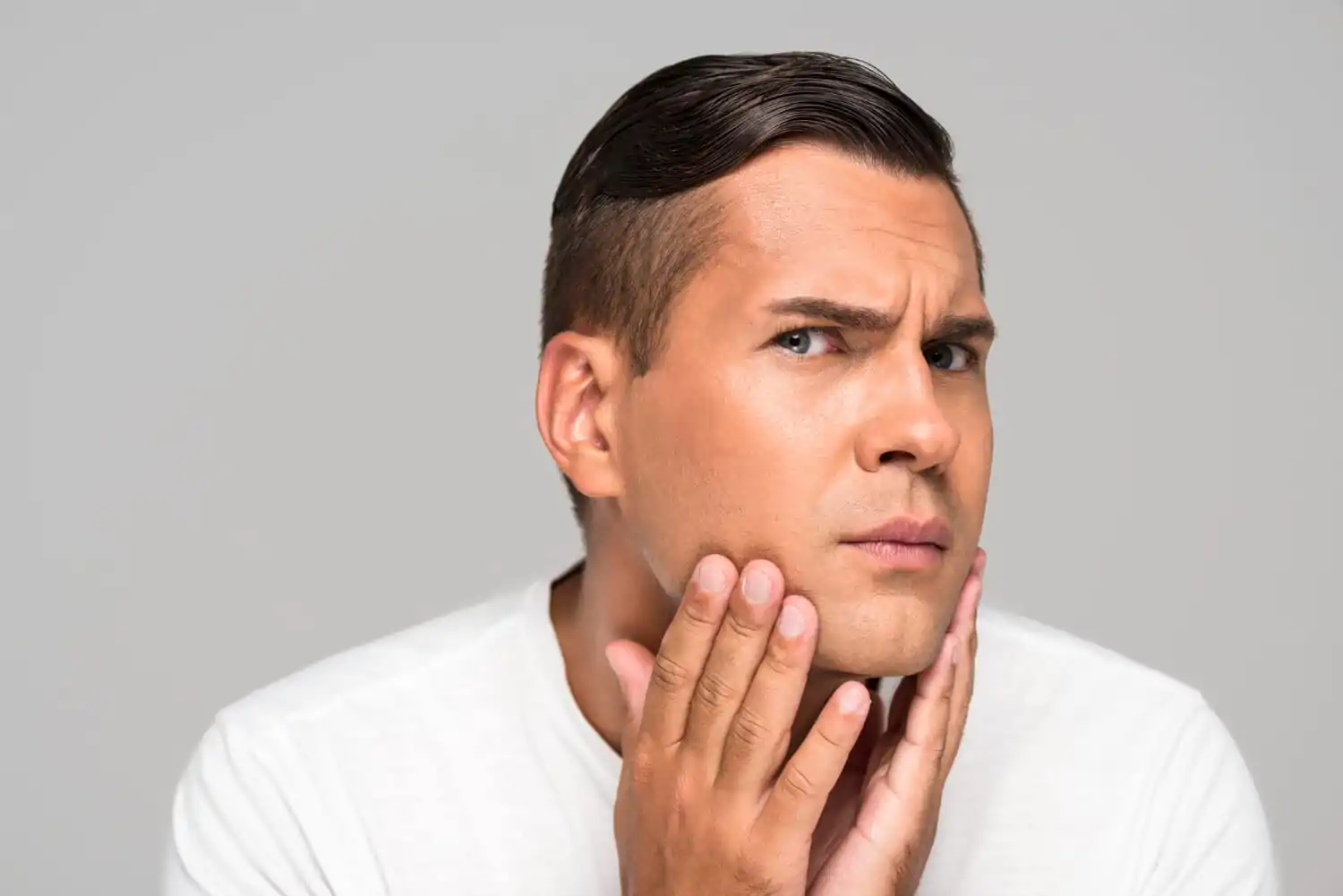 Man looking worried about his jawline before undergoing jawline contouring