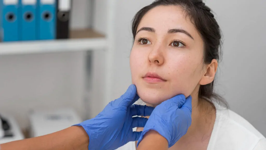 Patient consultation for chin filler reversal procedure with practitioner evaluating jawline