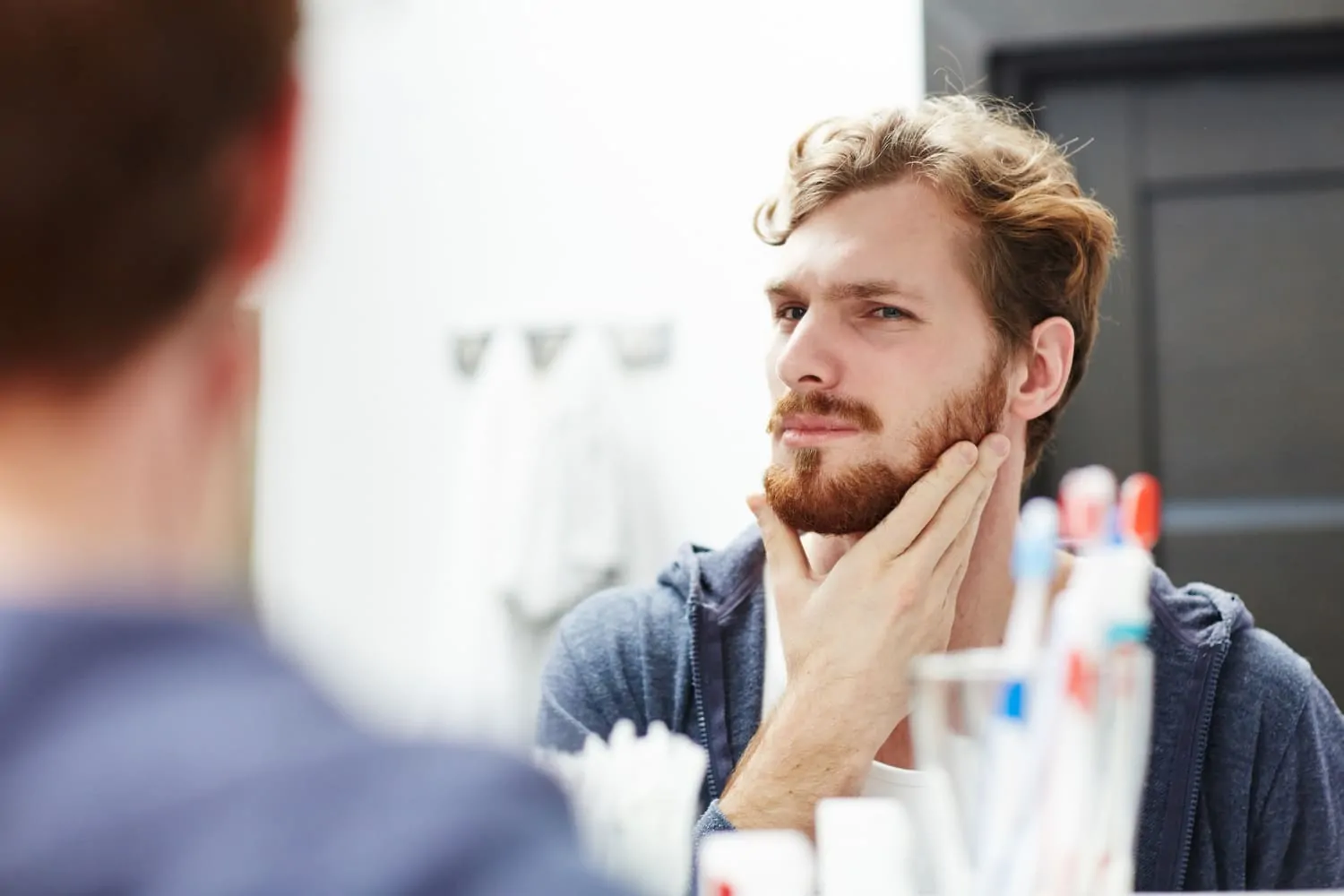 Man touching his jawline