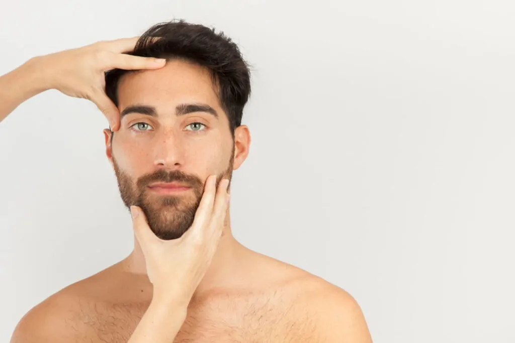 Hands touching a man's face after being injected with Botox