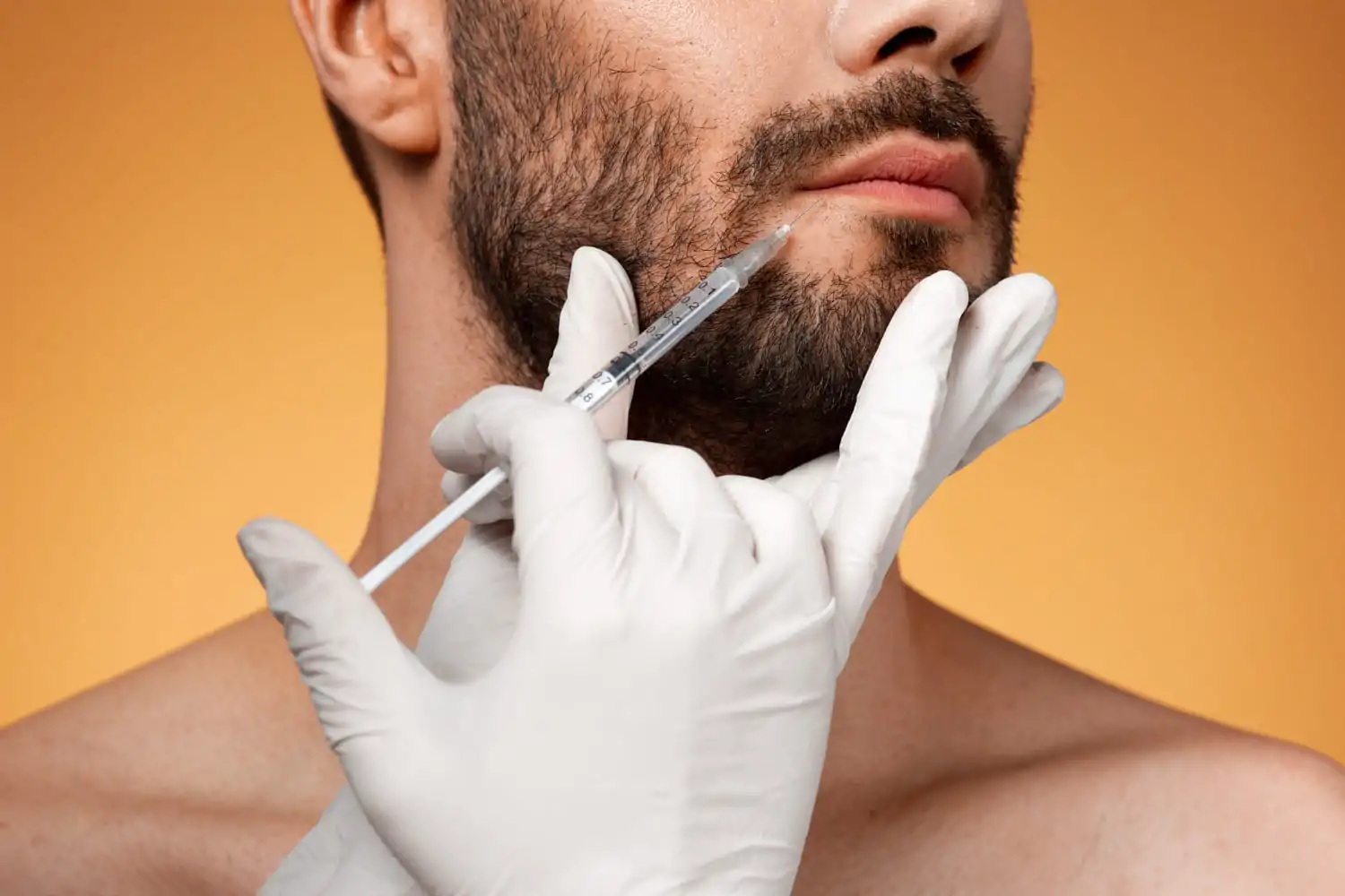 A medical professional in gloved hands administering a Botox injection around a man's mouth area to reduce fine lines and wrinkles