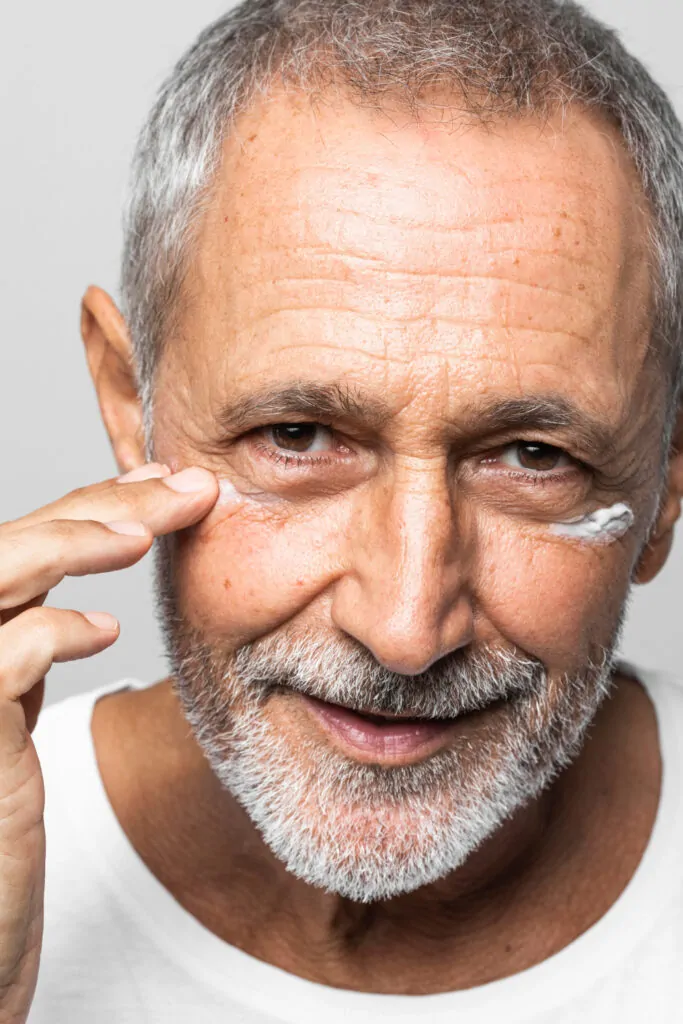 Close-up senior man applying cream