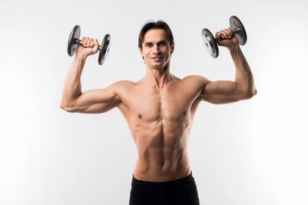 Fit man with toned physique holding dumbbells, representing ideal body composition and health status for surgical treatment candidacy