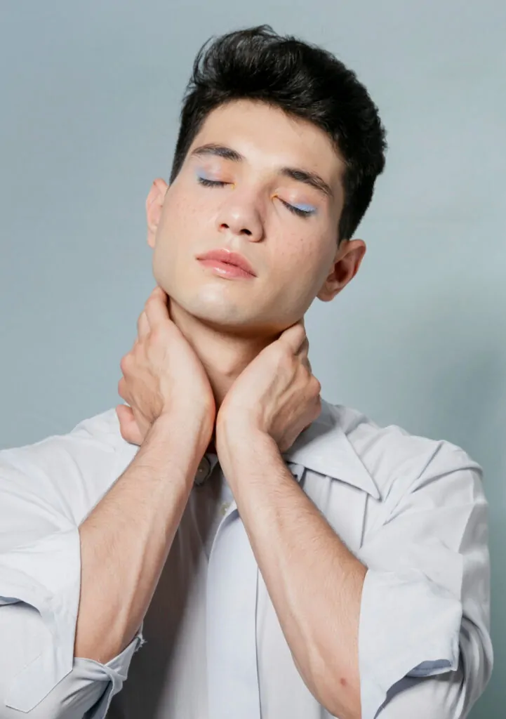 Man posing while holding his neck