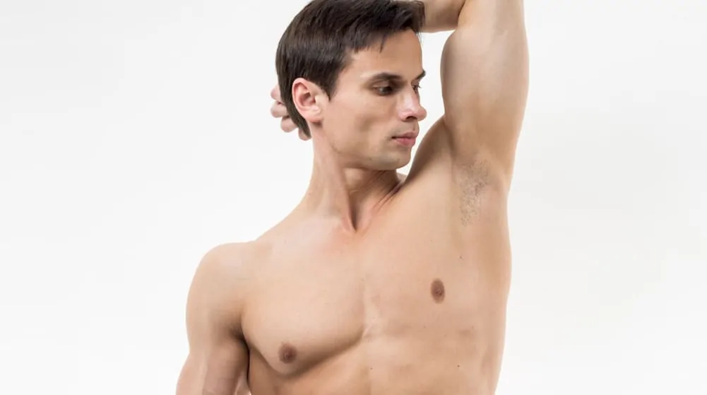 Shirtless man lifting his arm to expose his underarm area, illustrating the treatment zone for different types of underarm Botox procedures.