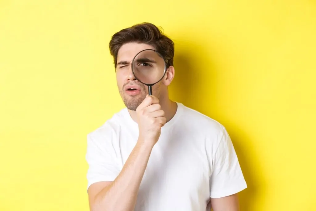 Man looking through magnifying glass