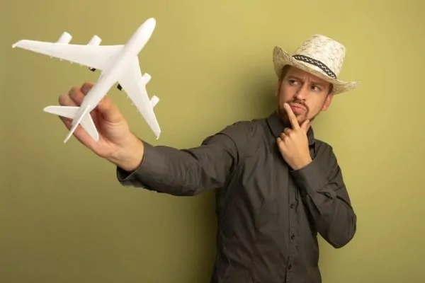 Man holding an airplane toy and thinking if it is safe to fly after getting Botox
