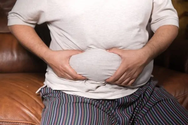 Man holding his bulging belly before liposuction