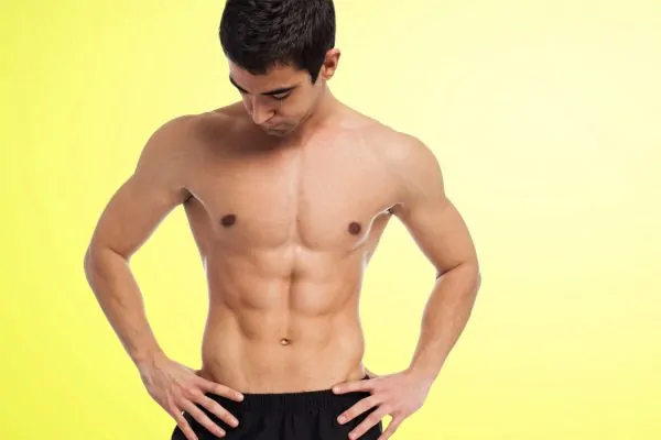 Muscular man without shirt after tummy tuck recovery