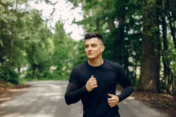 Sports man in a morning summer park after liposuction
