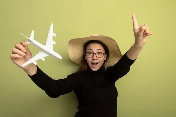Woman holding a toy plane planning on flying after having a plastic surgery