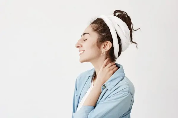 Woman massaging her neck after liposuction procedure