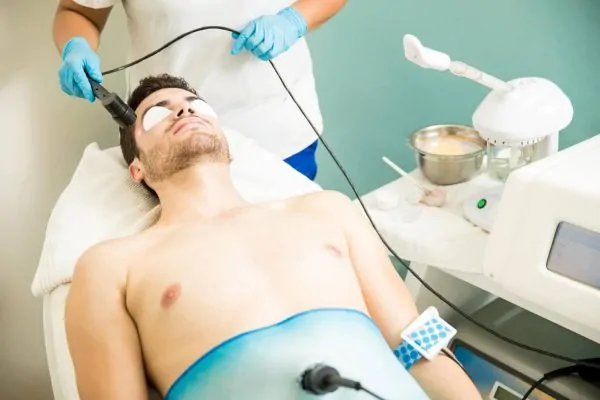 Young man getting radiofrequency and anti-aging therapy with peptides