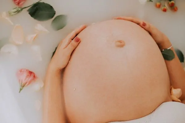 A pregnant woman in a bathtub, thinking about lipo results