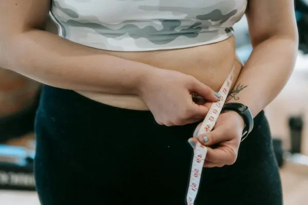 A woman measuring her waist