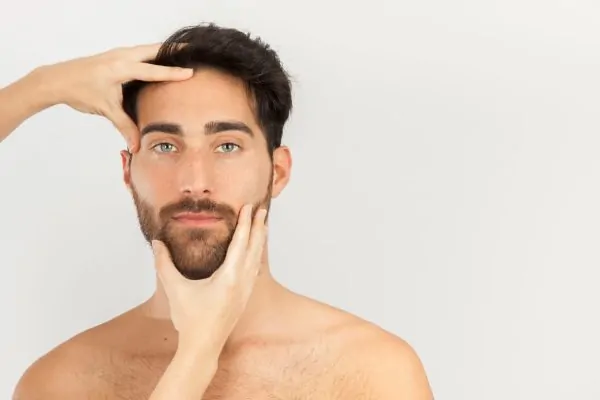 Hands touching a man's face after being injected with Botox