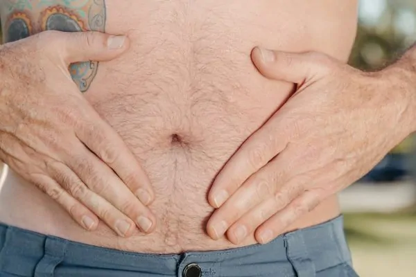 Man touching his stomach before getting a lipo revision