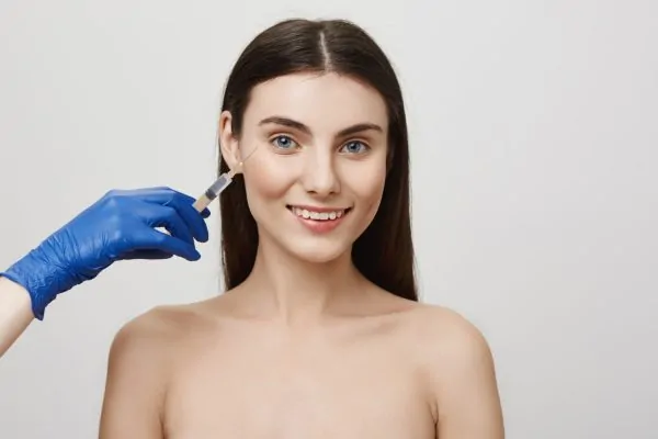 Medium shot of a woman in her 30s receiving Botox injection