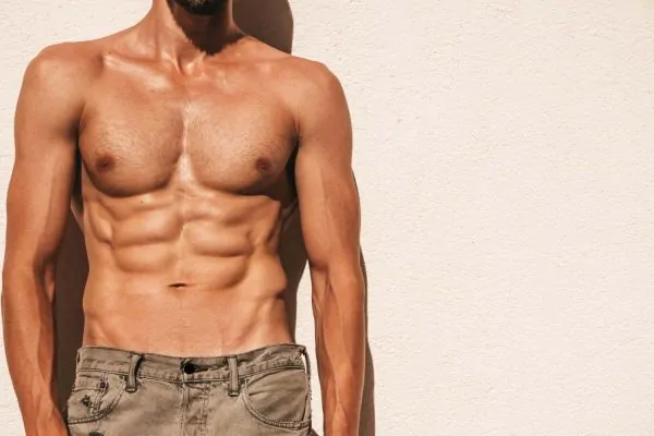 Portrait of handsome man flexing his abs after getting high definition liposuction
