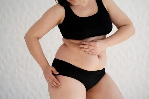 Side view woman touching her body before undergoing liposuction