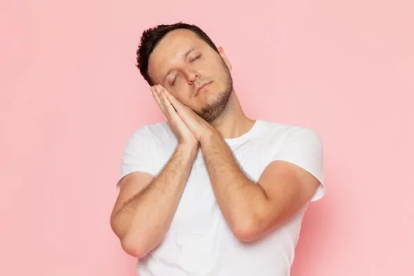 Young male in white shirt posing with sweet sleeping expression after getting PDO threads