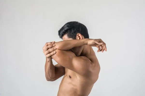 man flexing his body after male liposuction recovery