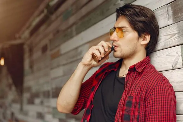Man vaping but thinking of getting a neck liposuction procedure