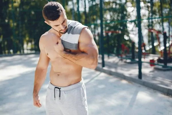 Shirtless man flexing his body after abdominoplasty