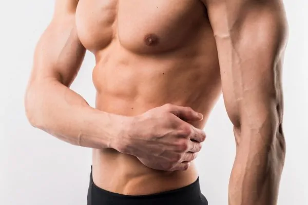 Side view of athletic man showing off muscles