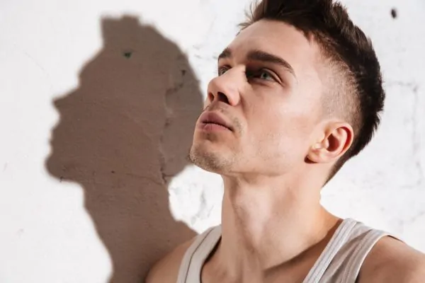 Young man posing and flexing his jaw after getting jawline fillers