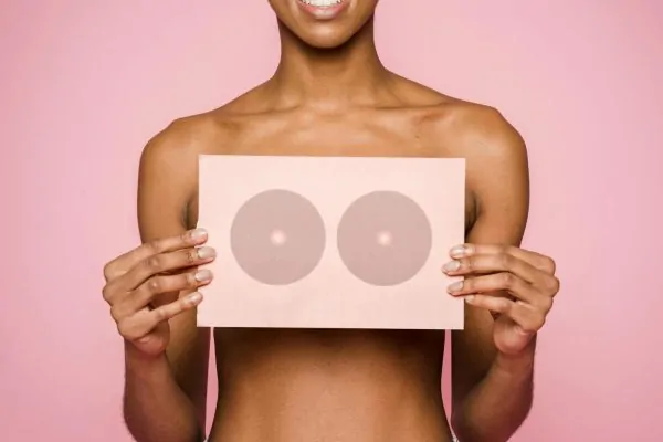 A woman holding a paper with breast print