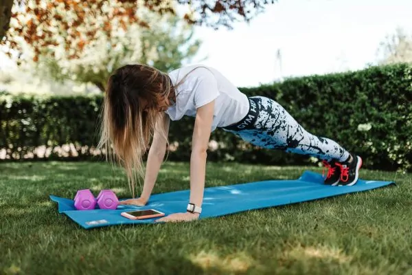 A woman holding a plank position outdoors