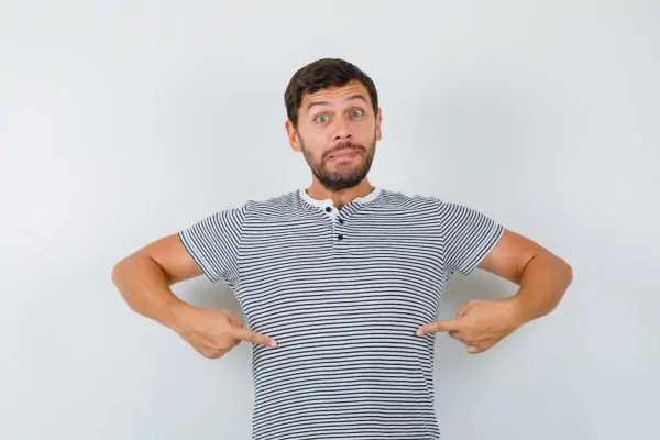 Man pointing at his belly and thinking if he can be a candidate for liposuction