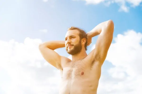 Man posing under the sun after plastic surgery recovery