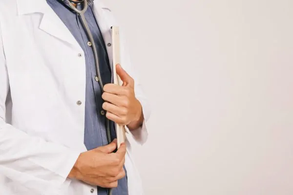 Plastic surgeon carrying a clipboard containing surgery procedure