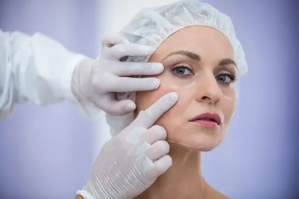 Plastic surgeon inspecting a patient’s face before surgery