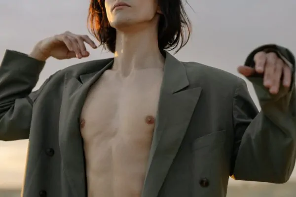 A man flexing his upper body after getting a full-body liposuction