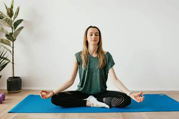 A woman doing yoga after a tummy tuck surgery