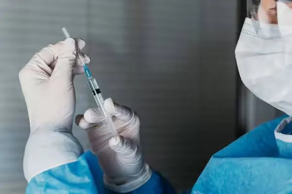 A doctor is administering anesthesia to a plastic surgery patient
