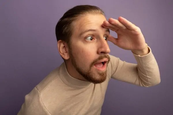 A man pressing his hand against his forehead with a surprised look, discovering additional important things to know about Botox for forehead wrinkles.