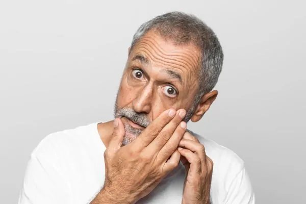 An older man with deep forehead wrinkles looking surprised, wondering if Botox can actually smooth out forehead lines.