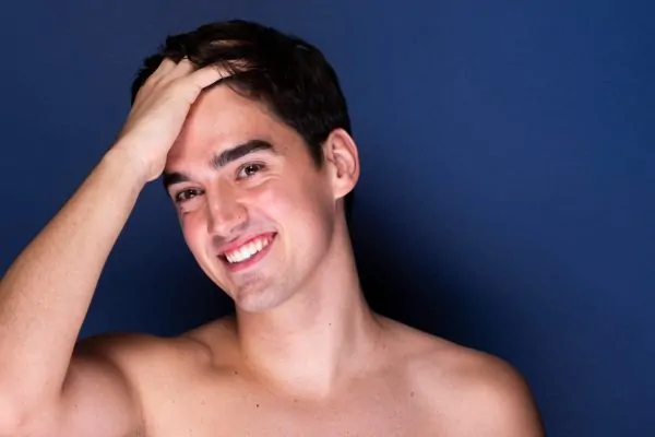 Confident young man with clear, radiant skin showcasing results of non-surgical cosmetic treatments