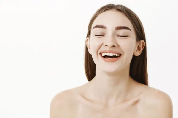Delighted charming young and beautiful woman closing eyes and smiling
