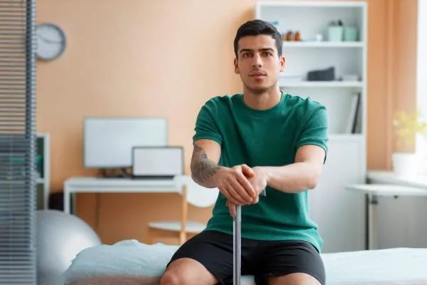 Male patient sitting in a recovery room following his high-definition liposuction procedure