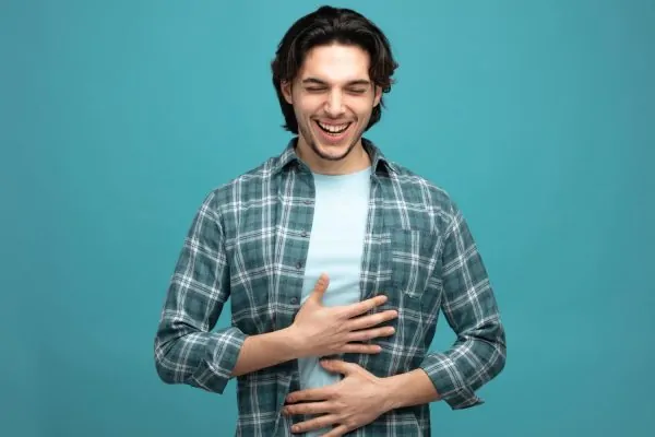 Man experiencing abdominal discomfort, demonstrating need for combined abdominoplasty and hernia repair surgery