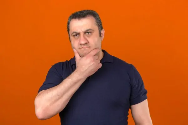 Man holding his chin and neck while thinking about the causes of turkey neck